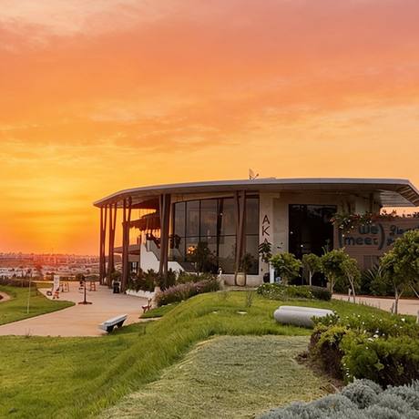 Le bâtiment de WeMeet Bouskoura au coucher du soleil, entouré de jardins