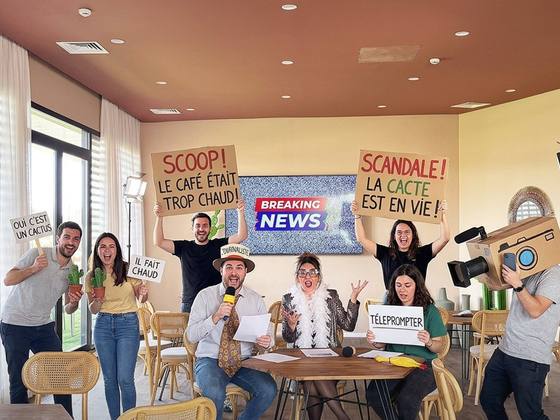Équipe brandissant des pancartes humoristiques pendant le tournage d’un journal télévisé