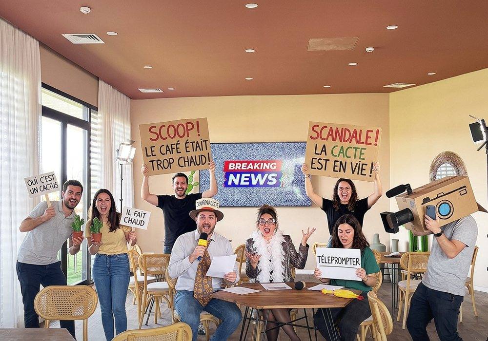 Équipe brandissant des pancartes humoristiques pendant le tournage d’un journal télévisé