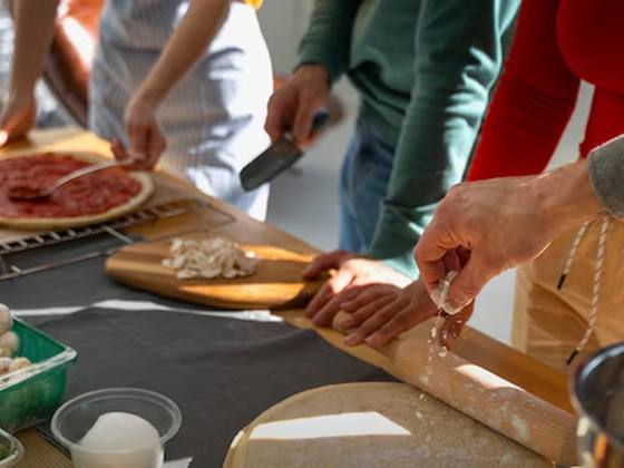 Mains préparant une pâte à pizza pendant l’atelier Master Chef
