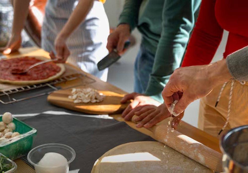 Mains préparant une pâte à pizza pendant l’atelier Master Chef