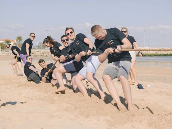 Équipe en plein tir à la corde sur la plage pendant les olympiades