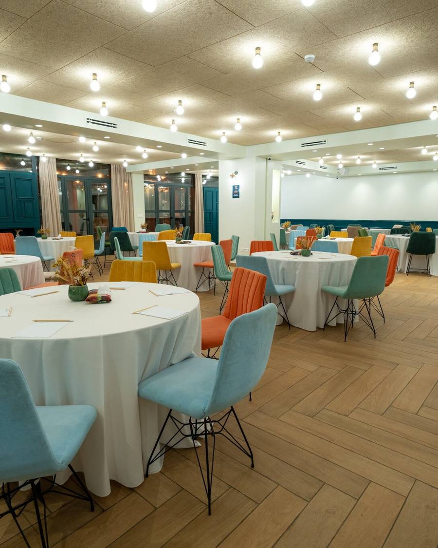 Salle de réunion WeMeet Anfaplace avec tables rondes et fauteuils colorés