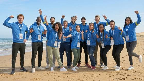 Équipe en tenue bleue célébrant une activité de team building sur la plage à Casablanca