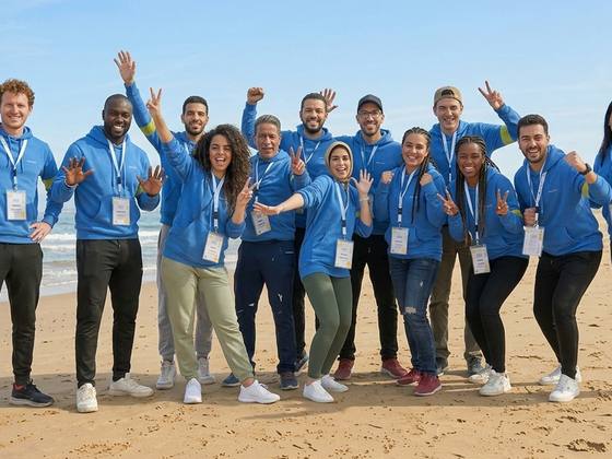 Équipe jubilant sur la plage après une activité de team building